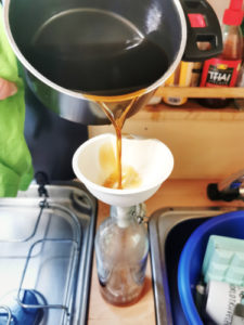 fertiger Kaffee Sirup in die vorgewärmte Glas-Flasche abfüllen