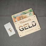 Geldgeschenk zu Weihnachten verpacken: Geldscheine schimmern durch die ausgeschnittenen Buchstaben GELD